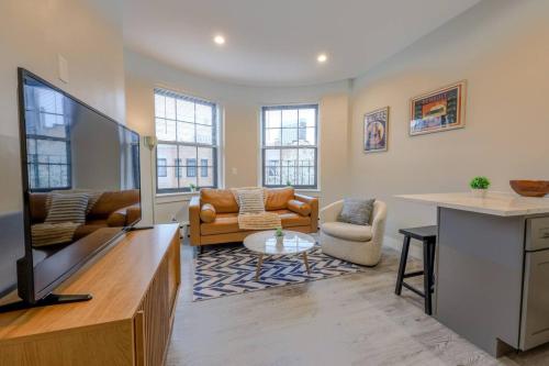 a living room with a flat screen tv at Spacious Studio Apt South End in Boston