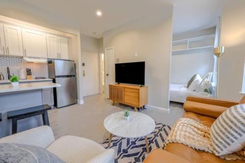 a living room with a couch and a table and a kitchen at Spacious Studio Apt South End in Boston