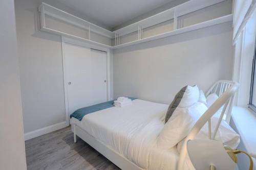 a white bedroom with a bed and a window at Spacious Studio Apt South End in Boston