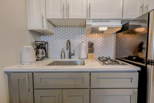 a kitchen with white cabinets and a sink at Spacious Studio Apt South End in Boston