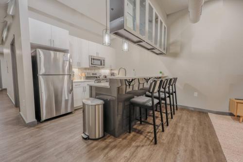 a kitchen with a refrigerator and bar stools at Luxurious Downtown 1 Bedroom in Boston