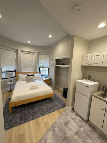 a large bedroom with a bed and a kitchen at Chic Metro South End Studio in Boston