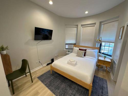 a bedroom with a bed and a tv on the wall at Chic Metro South End Studio in Boston