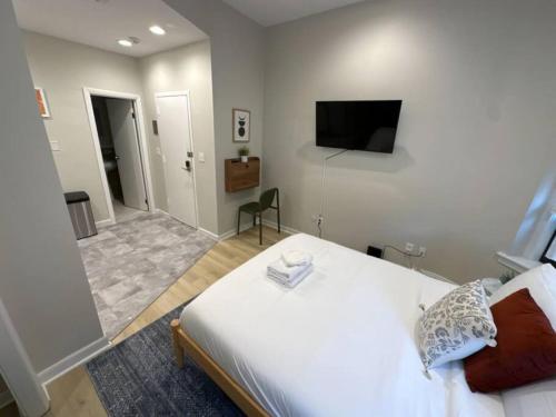 a bedroom with a bed and a tv on the wall at Chic Metro South End Studio in Boston