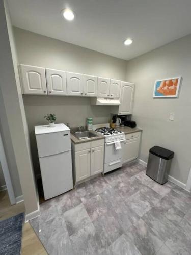 a kitchen with white cabinets and a stove top oven at Chic Metro South End Studio in Boston