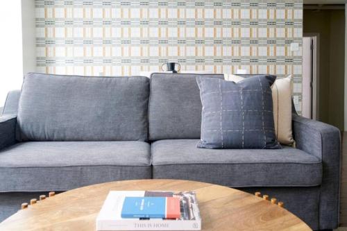 a living room with a gray couch and a wooden table at Lux 2br in the Heart of FIDI in Boston