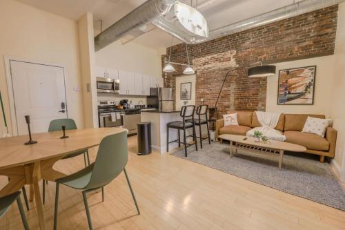 a living room and kitchen with a brick wall at Simple Spacious Apartment in Boston