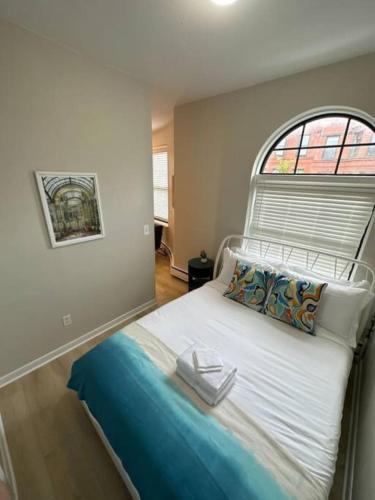 a small bedroom with a bed with a window at Modern studio apartment in Boston