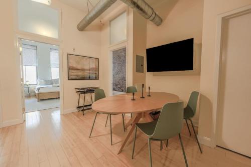 a dining room with a table and chairs and a tv at Simple Spacious Apartment in Boston