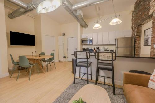 a living room with a table and chairs and a kitchen at Simple Spacious Apartment in Boston