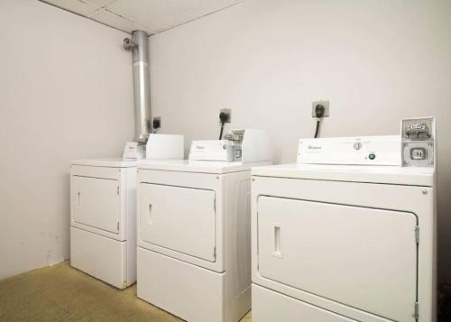 a room with white washers and dryers in a room at Serene Studio Close to MGH in Boston