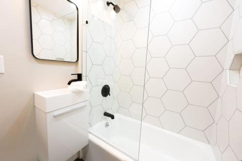 a white bathroom with a shower and a sink at Modern Bright Back Bay Studio in Boston