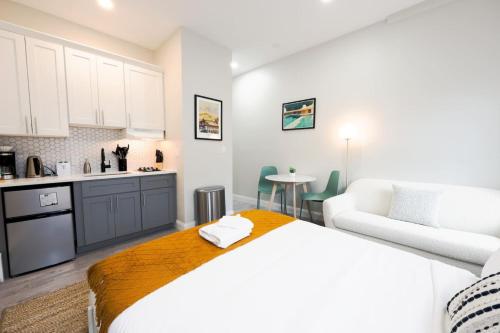 a bedroom with a white bed and a kitchen at Modern Bright Back Bay Studio in Boston
