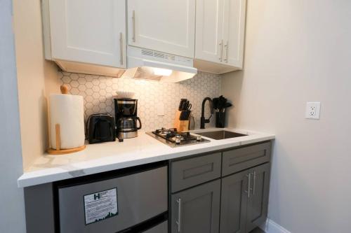 a small kitchen with white cabinets and a sink at Vibrant Studio in Prudential Area in Boston