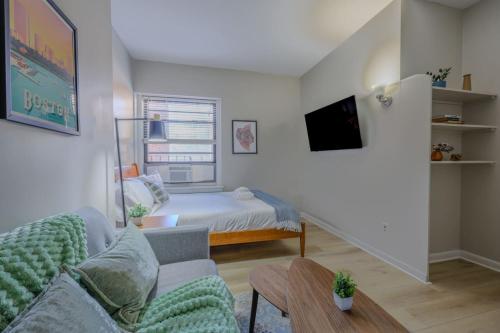 a small bedroom with a bed and a couch at Modern South End Studio Apt in Boston