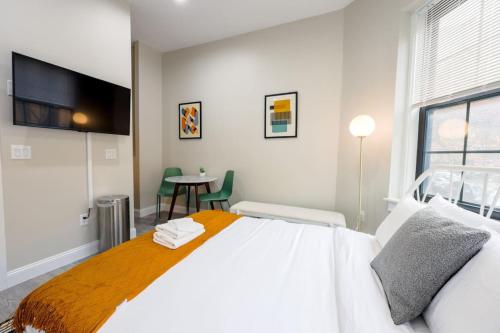 a bedroom with a large white bed and a table at Vibrant Studio in Prudential Area in Boston