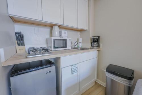 a small kitchen with a sink and a microwave at Modern South End Studio Apt in Boston