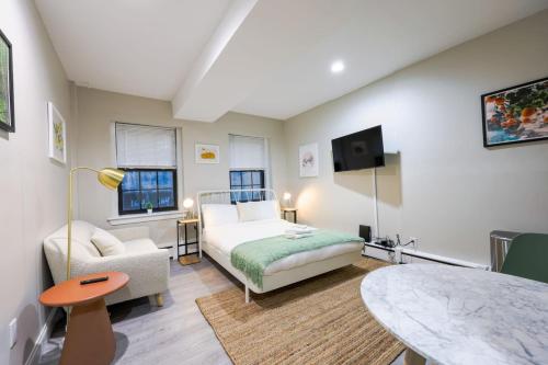 a bedroom with a bed and a couch and a table at Studio Nestled in Back Bay in Boston