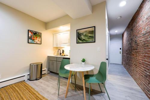 a kitchen with a table and chairs and a brick wall at Studio Nestled in Back Bay in Boston