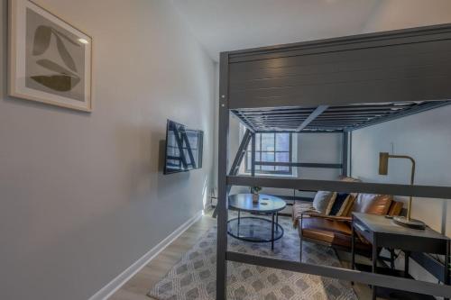 a loft bed in a room with a table and chairs at Cozy Studio South End in Boston