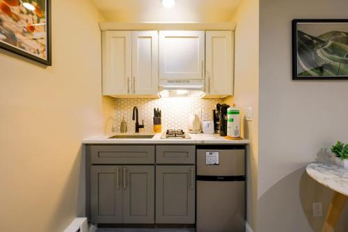 a small kitchen with white cabinets and a sink at Studio Nestled in Back Bay in Boston