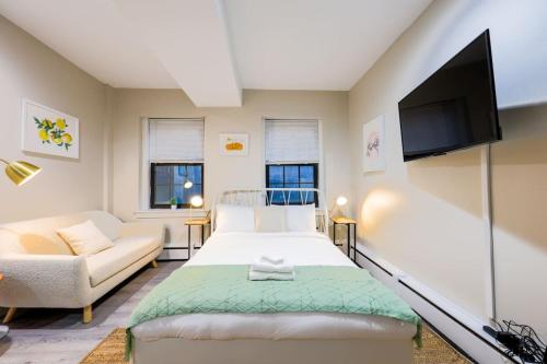 a bedroom with a bed and a couch and a tv at Studio Nestled in Back Bay in Boston