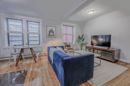 a living room with a blue couch and a table at Theater District Cozy 1 BR in Boston