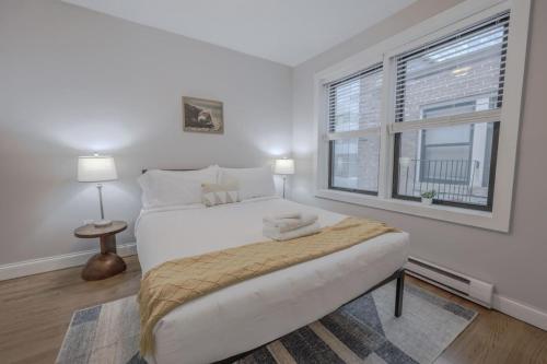 a white bedroom with a large bed and a window at Theater District Cozy 1 BR in Boston