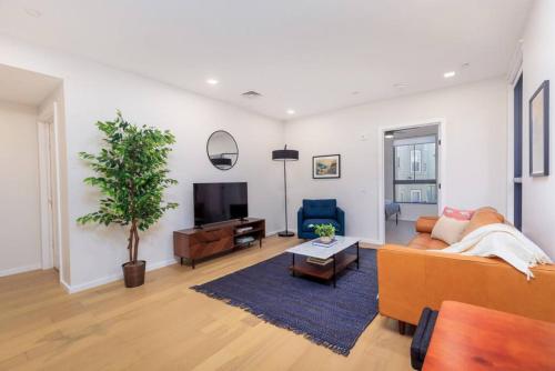 a living room with a couch and a tv at New Gorgeous 2Br Mission Hill in Boston