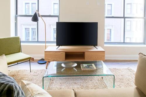 a living room with a flat screen tv on a coffee table at Bold and Spacious 2 Bed in Boston Financial District in Boston