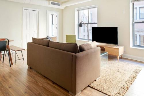 a living room with a couch and a flat screen tv at Bold and Spacious 2 Bed in Boston Financial District in Boston