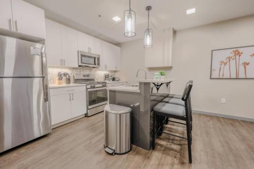 a kitchen with white cabinets and a stainless steel refrigerator at Charming 1 Bedroom Apt Laundry in Unit in Boston