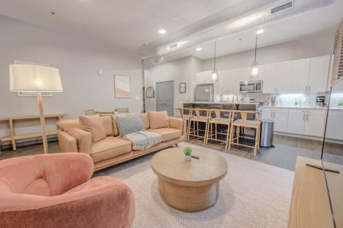 a living room with couches and a table and a kitchen at Elegant 2 Bedroom Prime Location in Boston