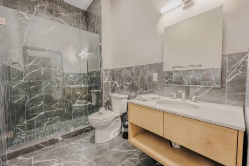 a bathroom with a toilet and a sink and a mirror at Elegant 2 Bedroom Prime Location in Boston