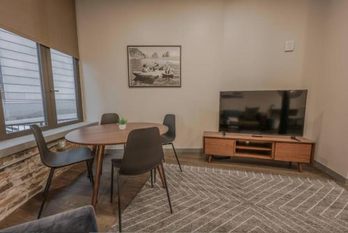a living room with a table and a tv at Classic and Chic Apartment 1 Bedroom in Boston