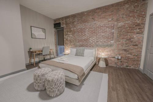 a bedroom with a bed and a brick wall at Stylish Downtown 2 Bedroom in Boston