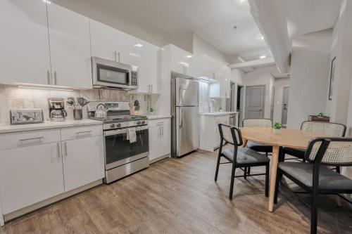 a kitchen with white cabinets and a table and chairs at Stylish Downtown 2 Bedroom in Boston