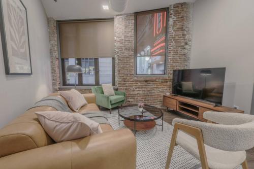 a living room with a couch and a television at Stylish Downtown 2 Bedroom in Boston