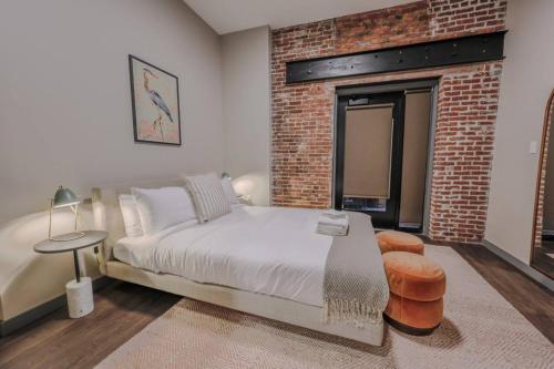 ein Schlafzimmer mit einem Bett und einer Ziegelwand in der Unterkunft Stylish Downtown 2 Bedroom in Boston