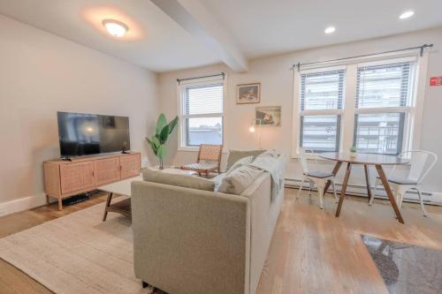 a living room with a couch and a tv and a table at Chic 1 Bed Apartment Steps from Boston Common in Boston