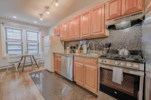 a kitchen with wooden cabinets and a stove top oven at Chic 1 Bed Apartment Steps from Boston Common in Boston
