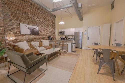 a living room with a couch and a brick wall at Stylish Exposed Brick 3 Bedroom in Boston