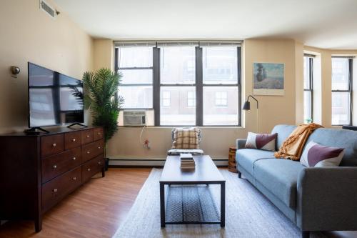 a living room with a couch and a tv at Financial District Charm and Close Walk to Downtown in Boston