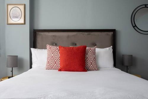 a bedroom with a white bed with two red pillows at Cozy Back Bay Studio and Close to Fenway in Boston