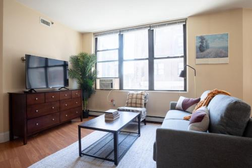 a living room with a couch and a tv at Financial District Charm and Close Walk to Downtown in Boston