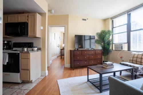 a living room with a kitchen and a living room with a table at Financial District Charm and Close Walk to Downtown in Boston