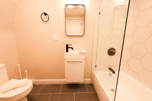 Un baño con ducha, inodoro y lavabo. en Cozy Garden Level Studio, en Boston