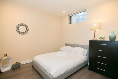 a bedroom with a bed and a dresser with a mirror at Newly Designed Loft - Fast Wifi - Pet Friendly in Boston