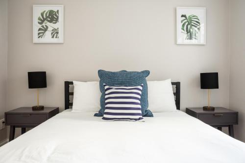 een slaapkamer met een wit bed en 2 nachtkastjes bij 1 Bedroom in Heart of Theater District Walk Anywhere in Boston