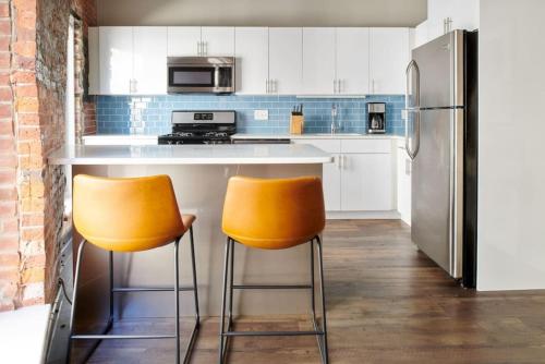 een keuken met twee oranje stoelen aan een aanrecht bij Spacious 4bed Loft Downtown Boston Beacon Hill in Boston